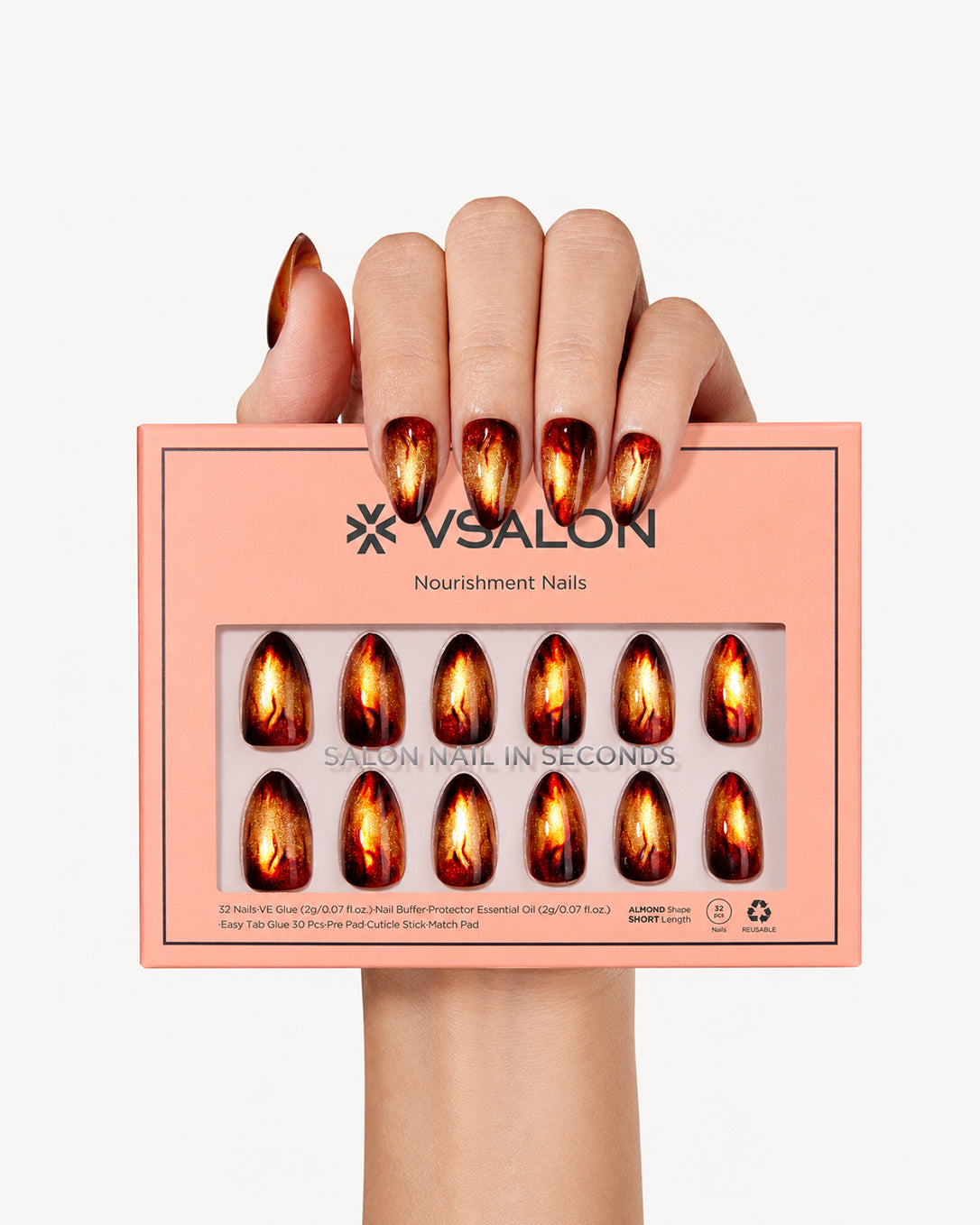 Hand holding VSALON Amber Whisper press-on nails with a warm amber cat-eye manicure and elegant flame-inspired details.