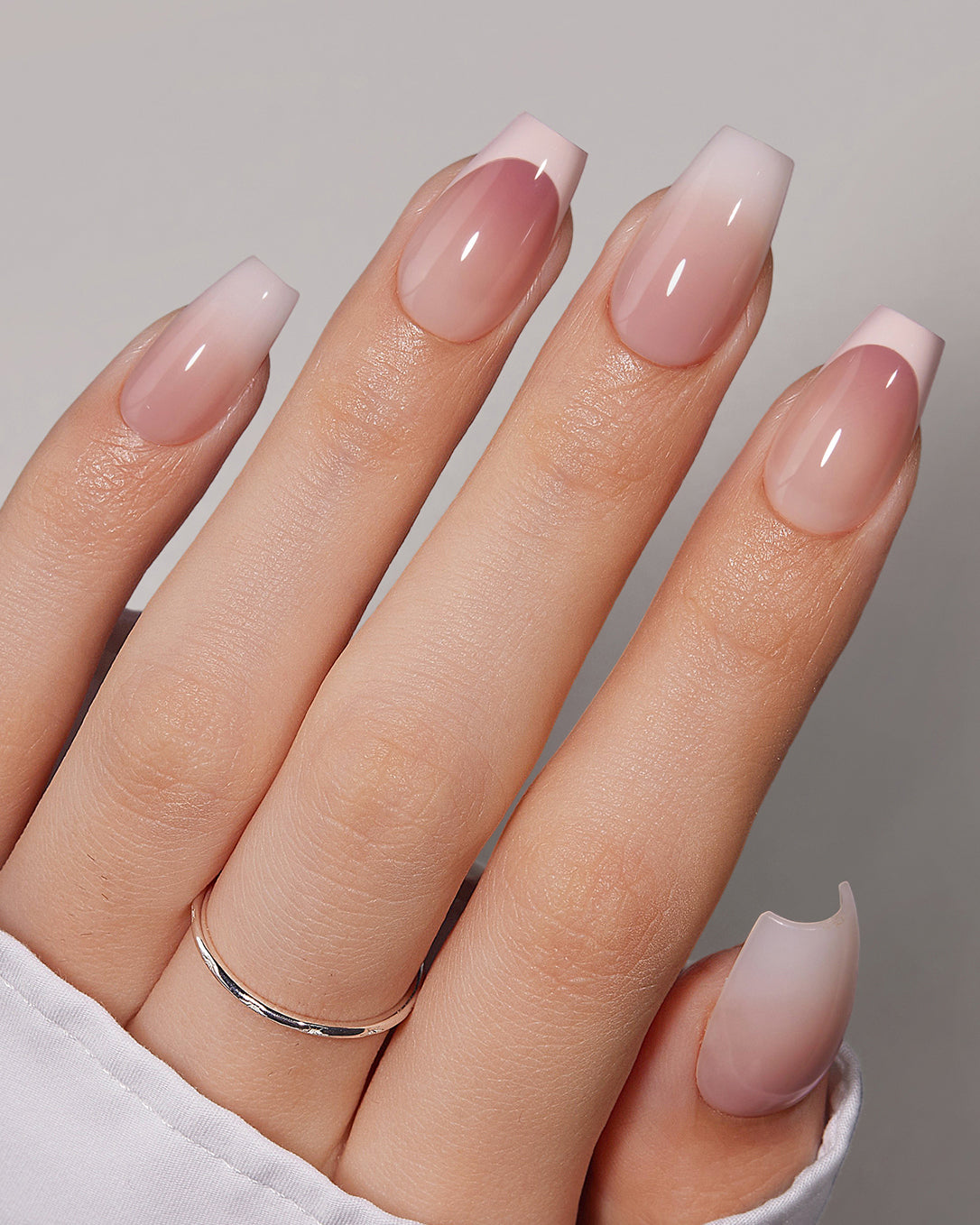 Belle De Jour nude pink French tip coffin short press-on nails worn with a chic mixed manicure look