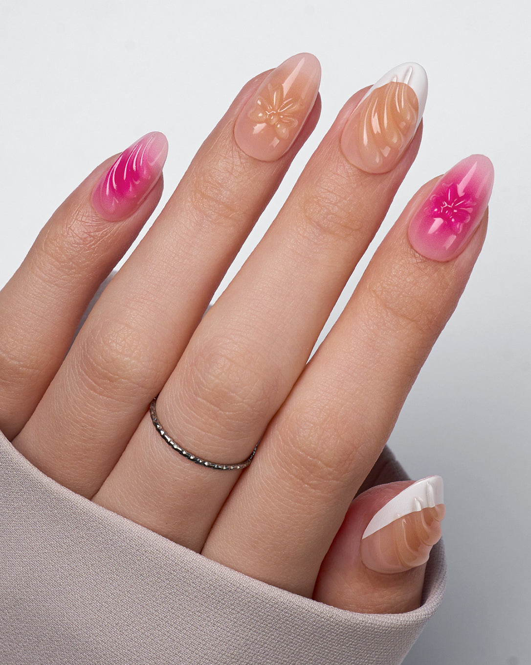 Barlow Girl pink gradient floral press-on nails styled on hands creating a romantic spring manicure look with delicate flower nail designs