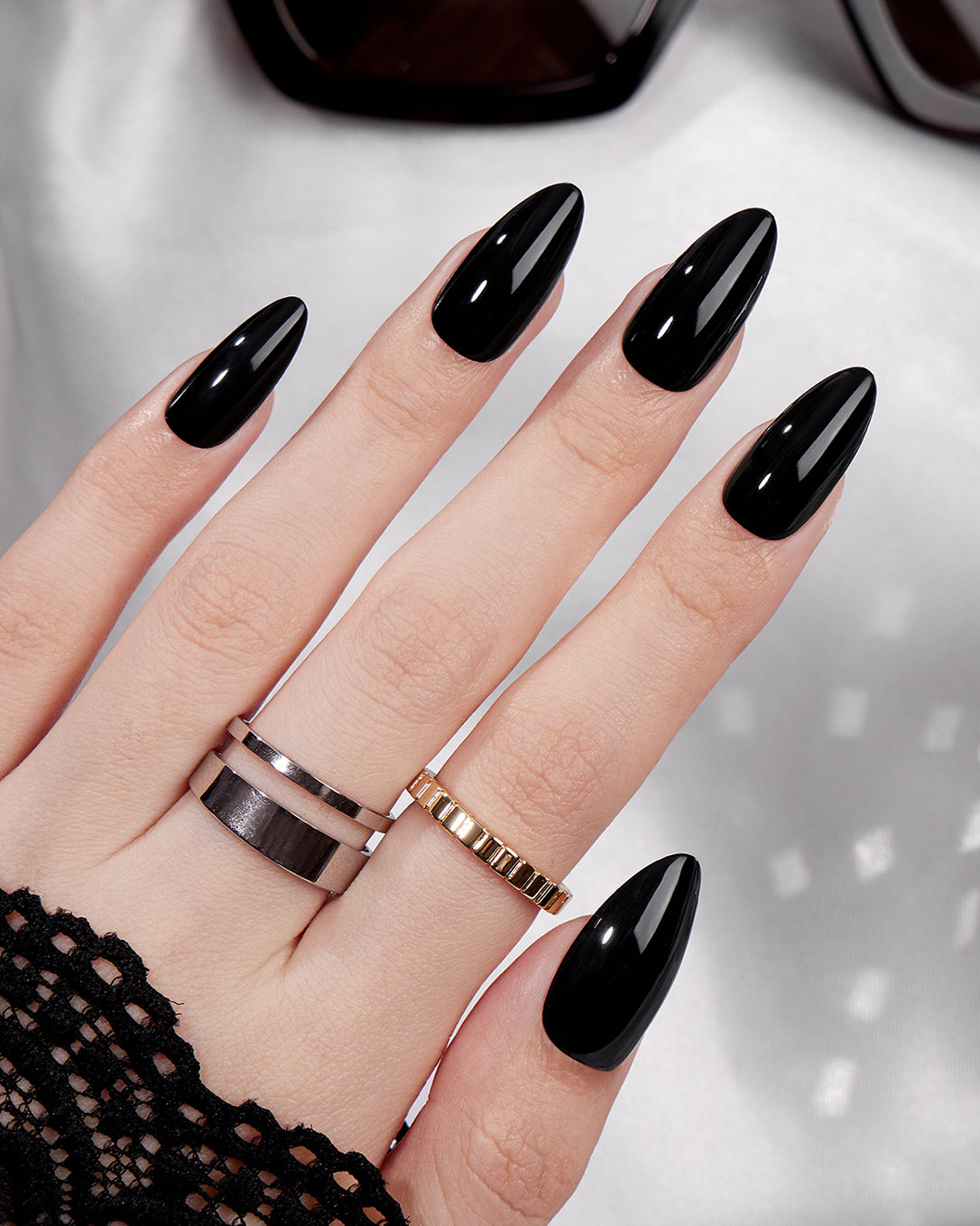 Noctis glossy black almond press-on nails creating a chic, elegant and statement manicure look