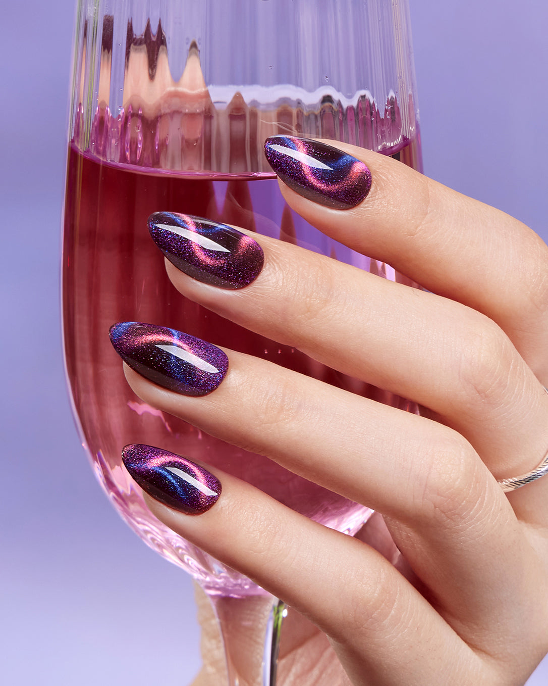 Model wearing VSALON Cosmos press-on nails featuring a stunning aurora cat-eye manicure with shifting multi-color reflections.