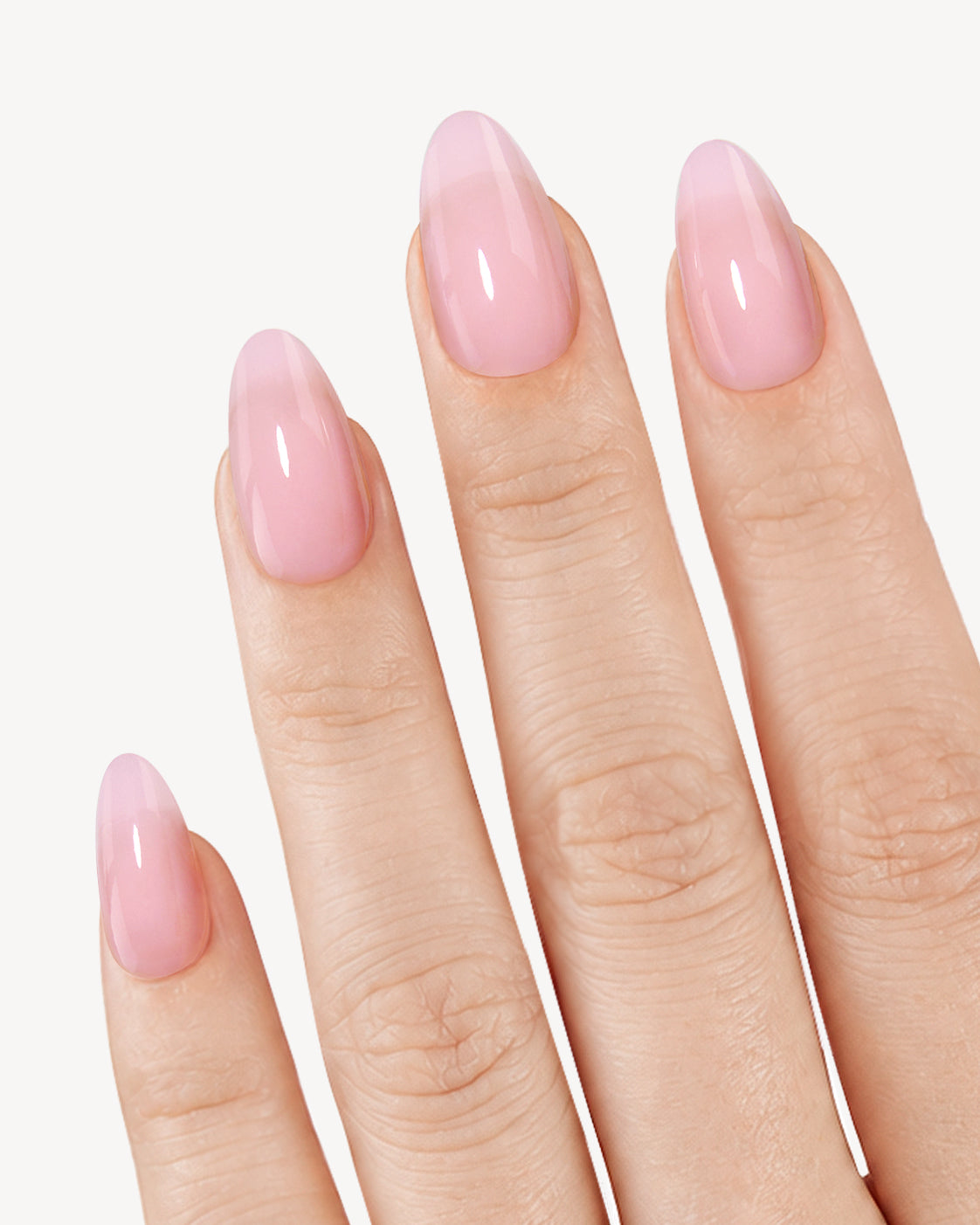 VSALON Pink Princess short almond soft gel press-on nails worn on hand in a translucent glossy pale pink shade
