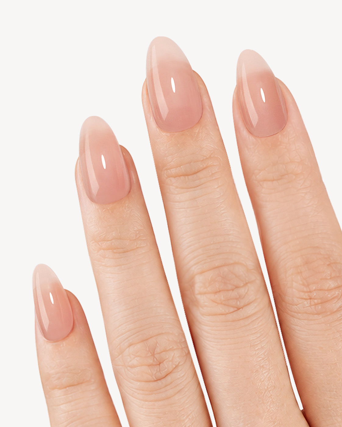 VSALON Sweetheart Fragrance short almond soft gel press-on nails worn on hand in a sheer glossy peachy nude shade