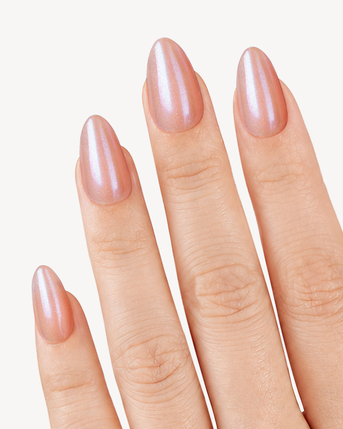 VSALON Sweet Temptation short almond soft gel press-on nails worn on hand with a peach-pink base and pearly shimmer