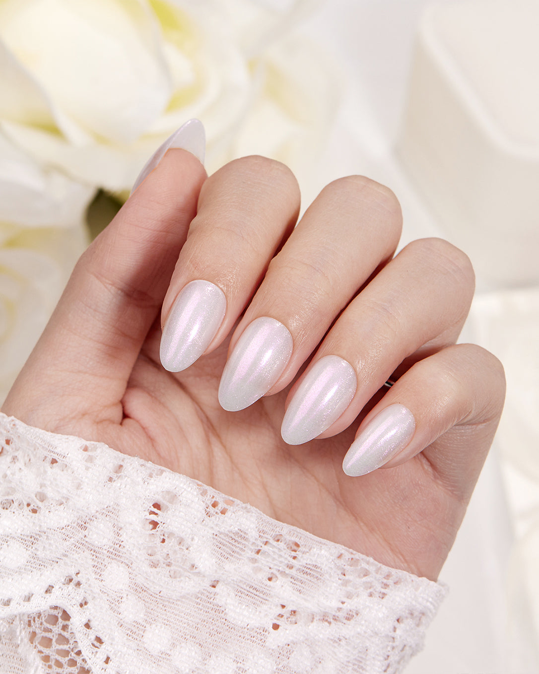 Aurora's Angel white pearl shimmer almond short press-on nails worn with a glossy natural manicure look