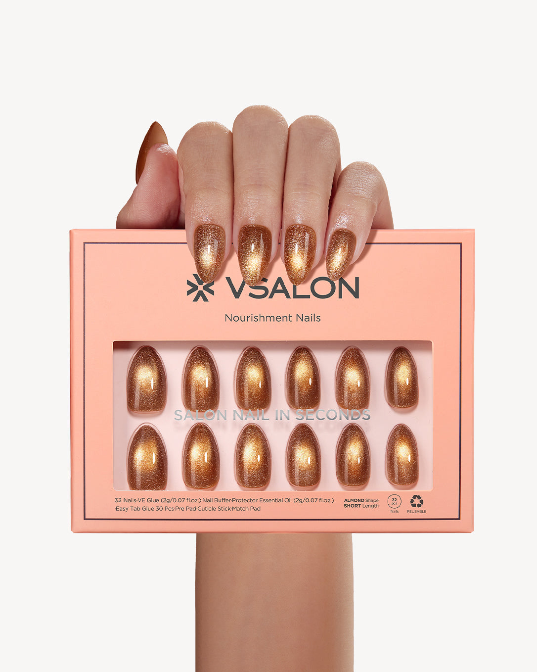 Hand holding VSALON Truffle Halo press-on nails with a warm toffee brown cat-eye manicure and golden shimmer effect.