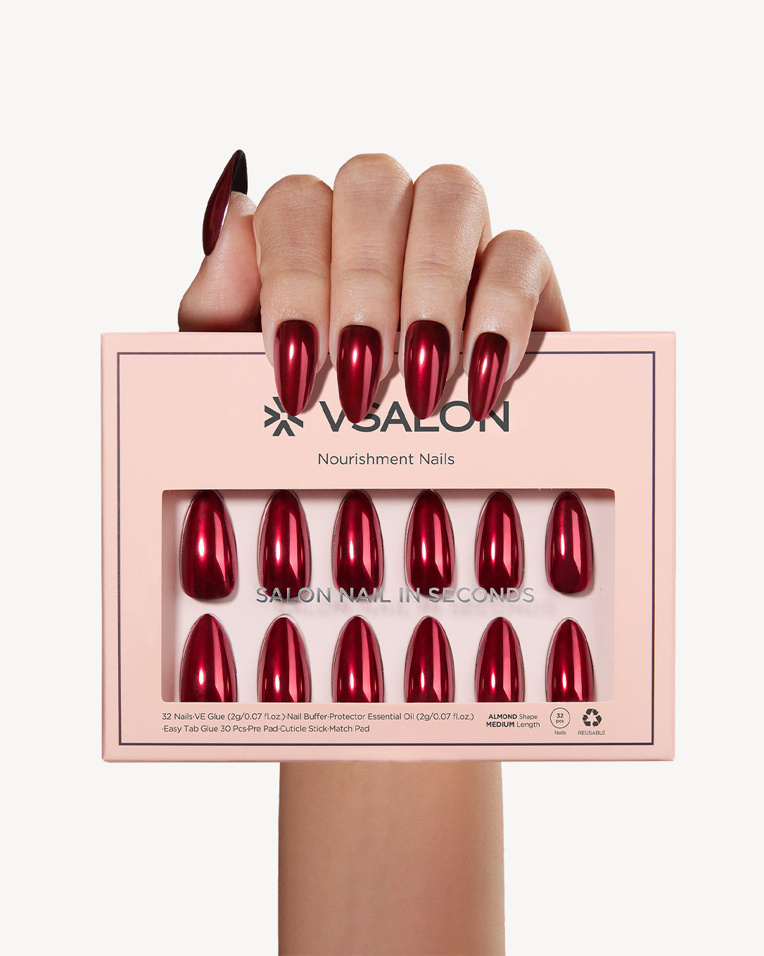 Hand holding VSALON Bourgogne Glide press-on nail set with a glossy metallic ruby red finish.