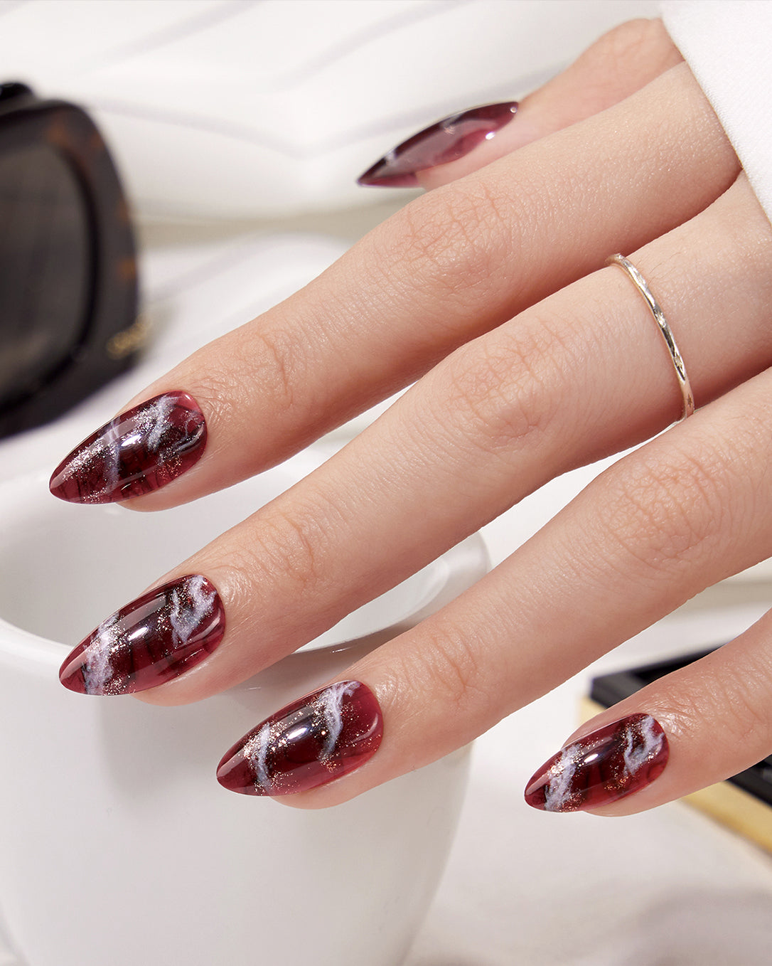 Model wearing VSALON Smoky Marble press-on nails featuring an elegant brown marble manicure for a refined seasonal look.