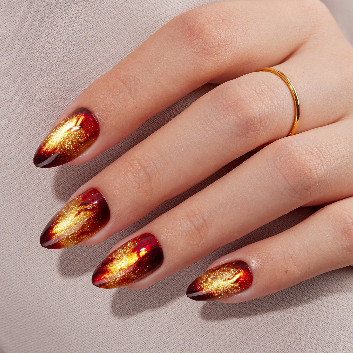 VSALON Nourishment Amber Whisper Golden Brown Cat Eye Flame Medium Almond Press On Nails - model's hand resting on elbow – showcasing nail style and elegant manicure