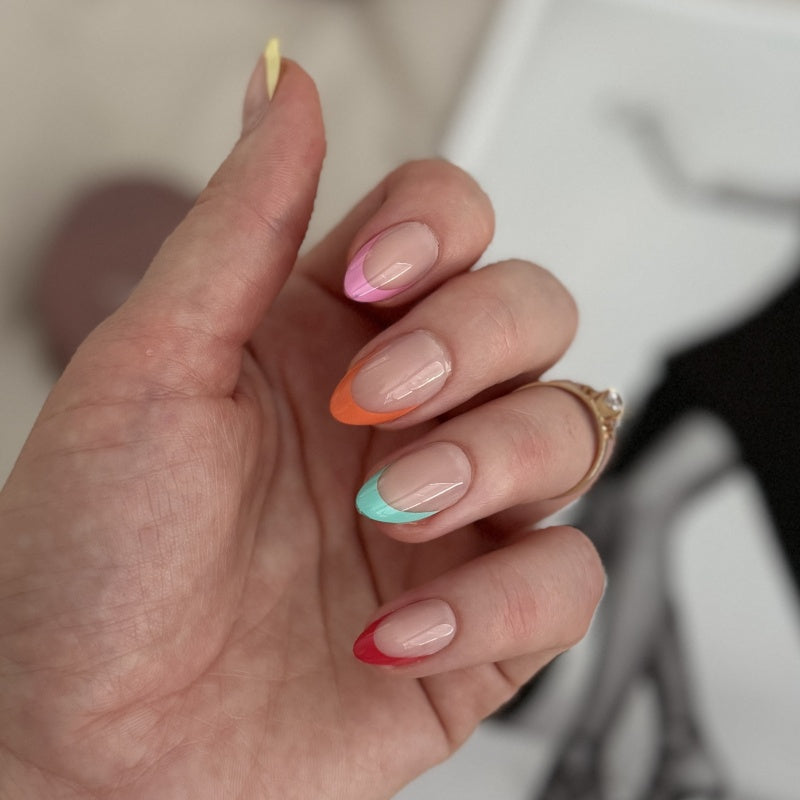 VSALON Nourishment Color Pop French Tips Short Almond Press On Nails - Close-up of model's hand bending fingers to hold VSALON press on nails – highlighting nail design and color details