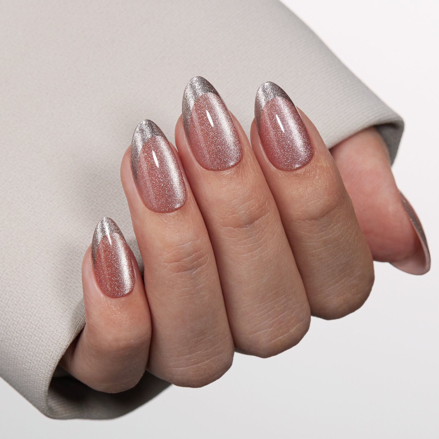 VSALON Nourishment First Dance Pink Metallic French Tips  Short Almond Press On Nails - Close-up of model's hand bending fingers to hold VSALON press on nails – highlighting nail design and color details