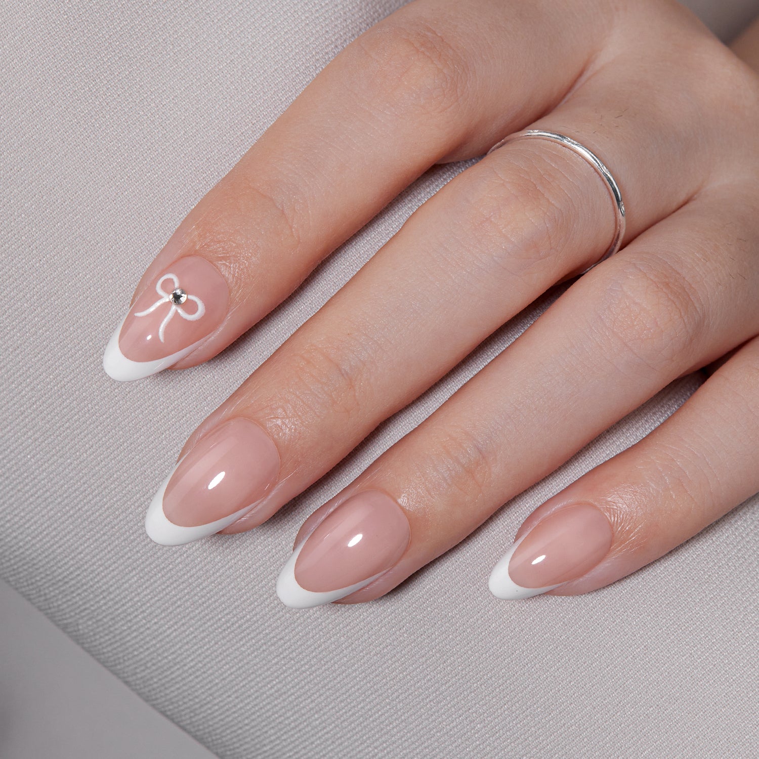 VSALON Dual Glam Nails Lovers Note Bow French Tips Short Almond Press On Nails - model's hand resting on elbow – showcasing nail style and elegant manicure