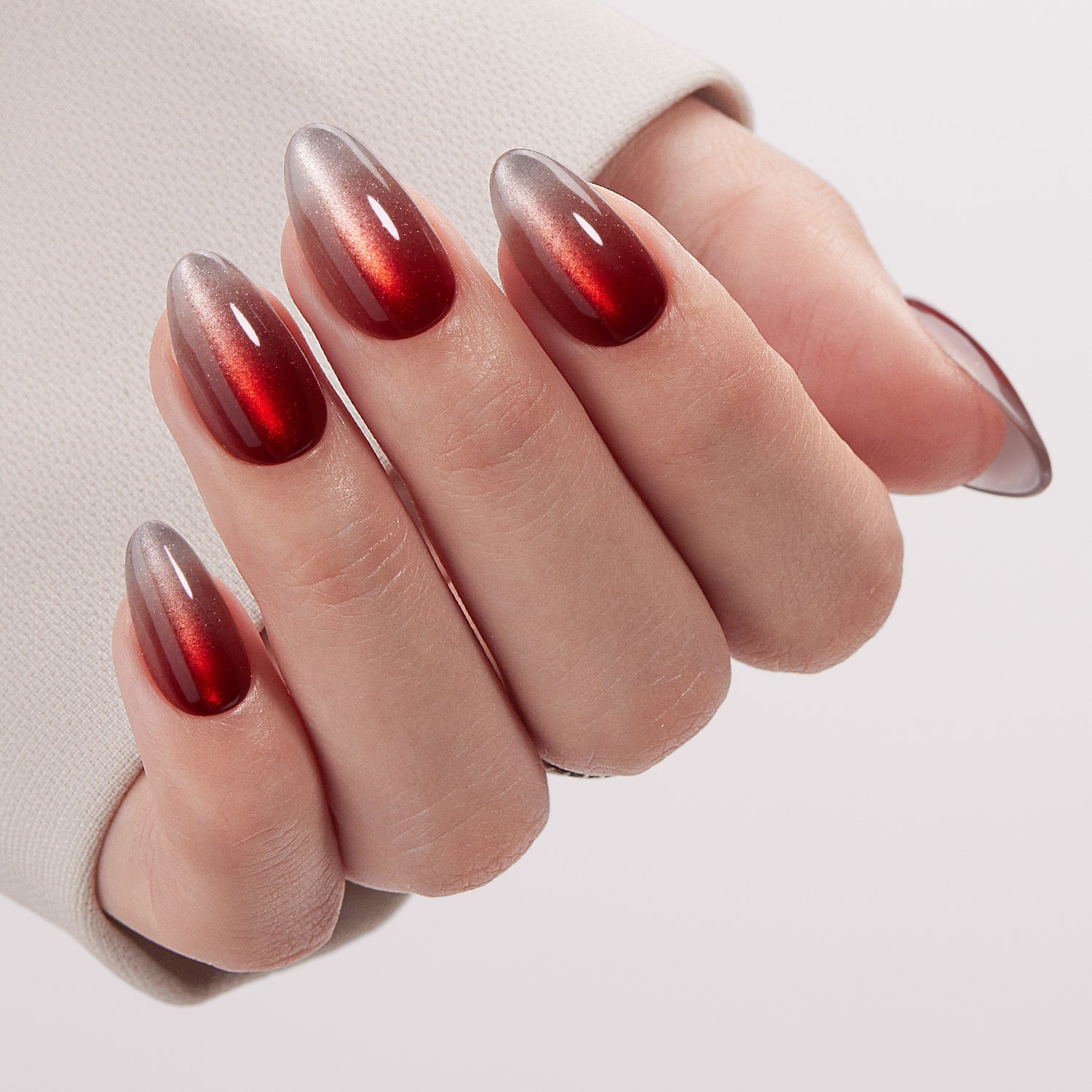 VSALON UV Cure Nails Scarlet Spell Red Cat Eye Short Almond Press On Nails - Close-up of model's hand bending fingers to hold VSALON press on nails – highlighting nail design and color details