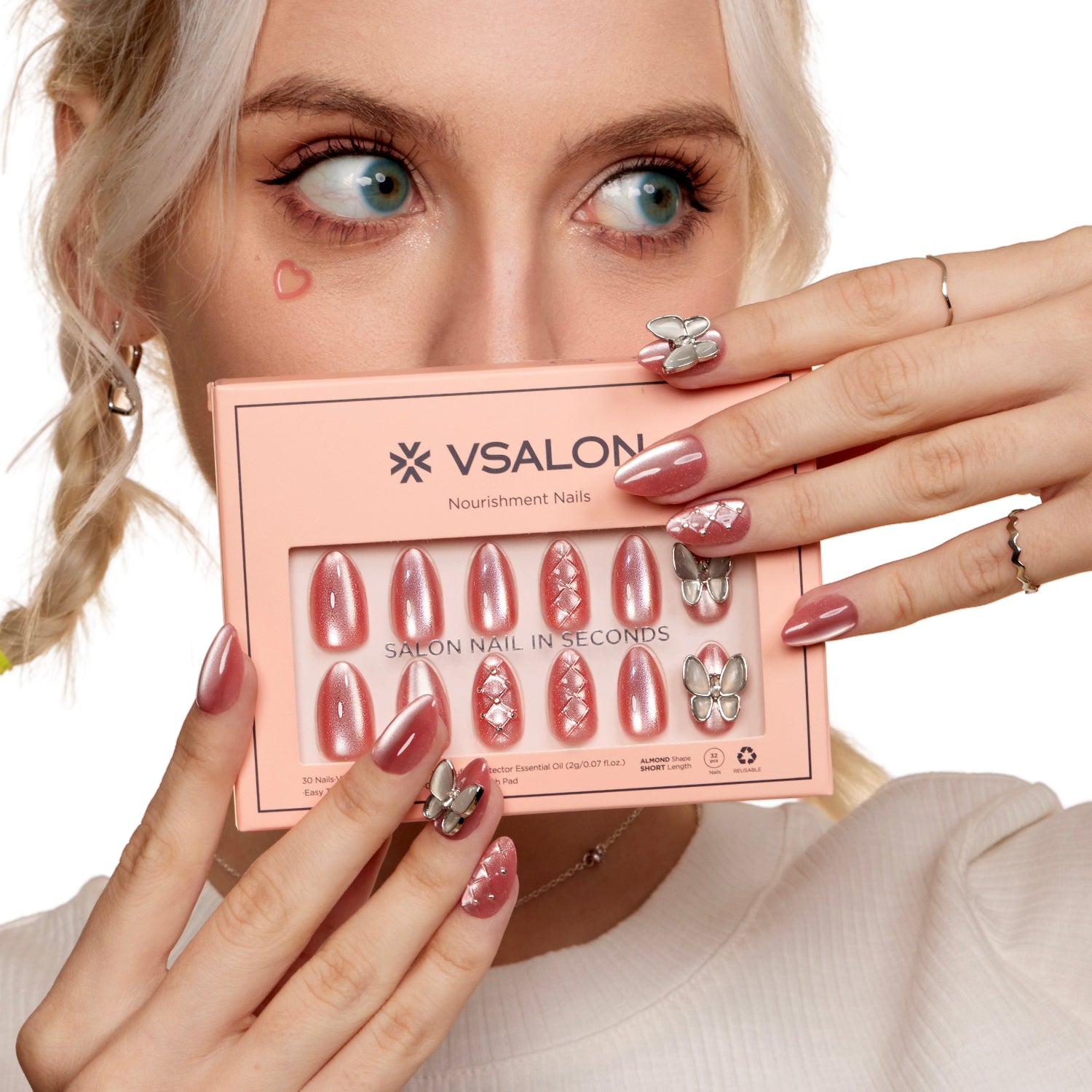VSALON Nourishment Starlight Shines Pink Butterfly Short Almond Press On Nails - Model holding VSALON press on nails box diagonally with both hands – highlighting packaging and nail set presentation