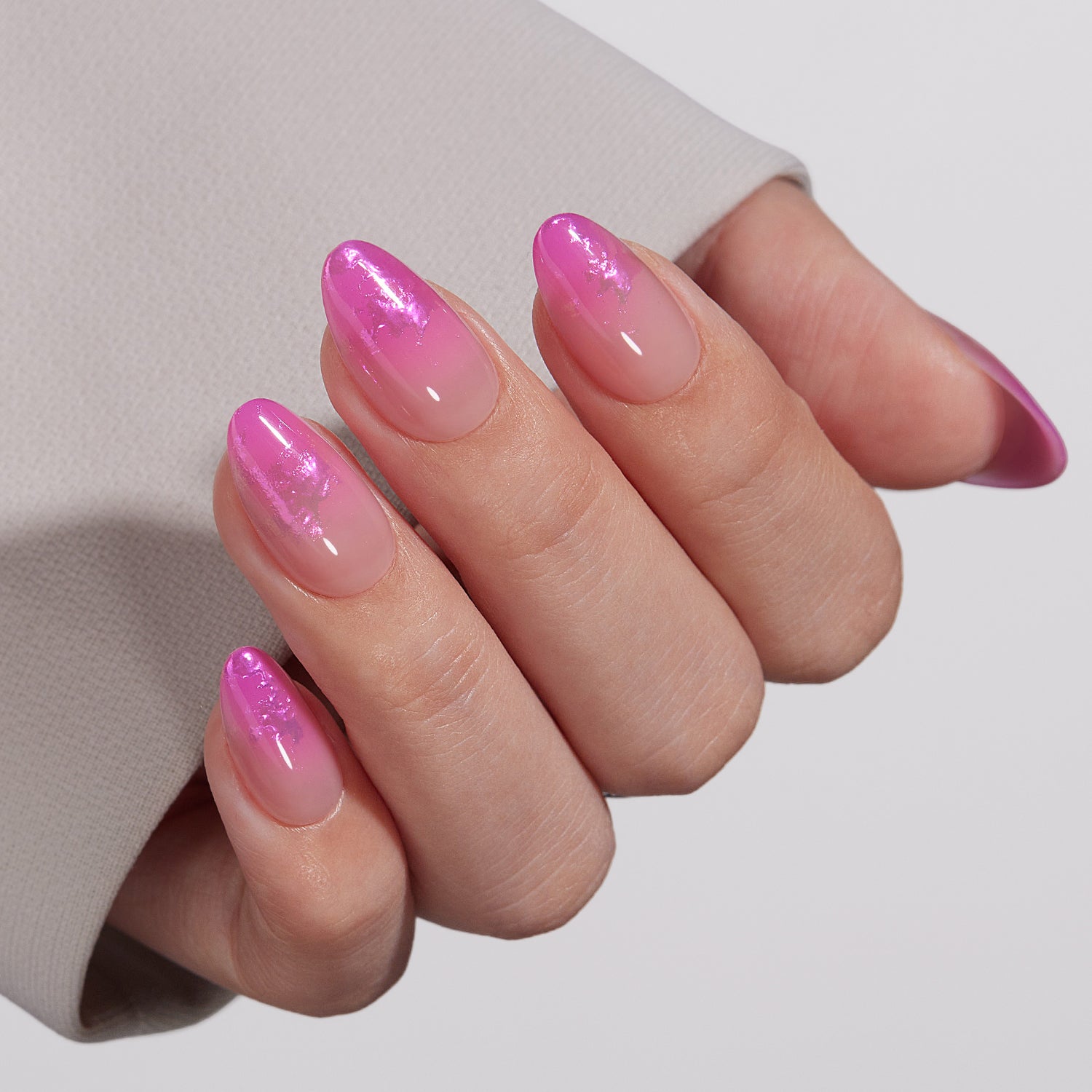 VSALON UV Cure Nails Unicorn Petal Gradient Flamingo Foil Pink Short Almond Press On Nails - Close-up of model's hand bending fingers to hold VSALON press on nails – highlighting nail design and color details